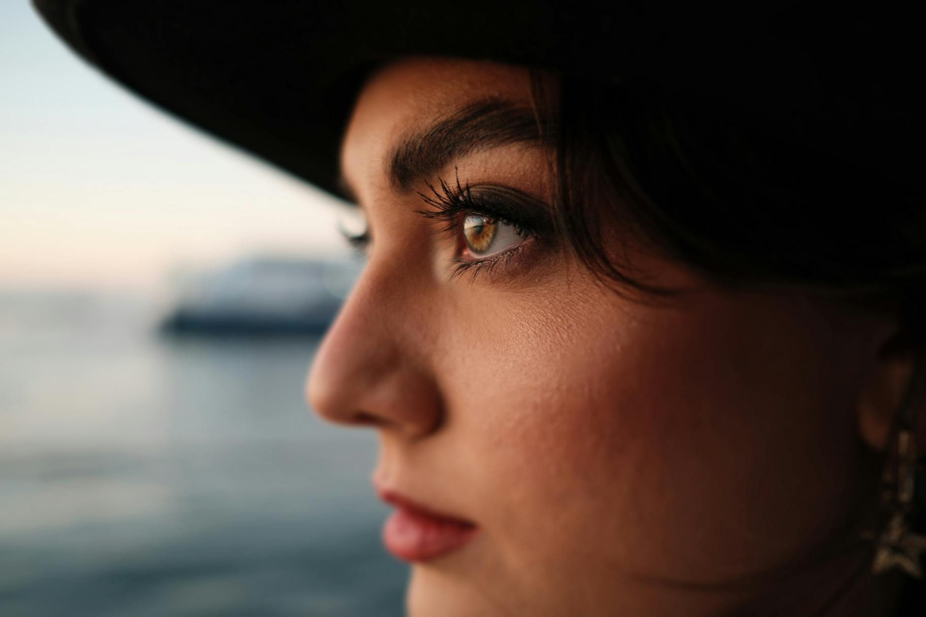 Kobieca sylwetka nad wodą o zachodzie słońca, artystyczne zbliżenie