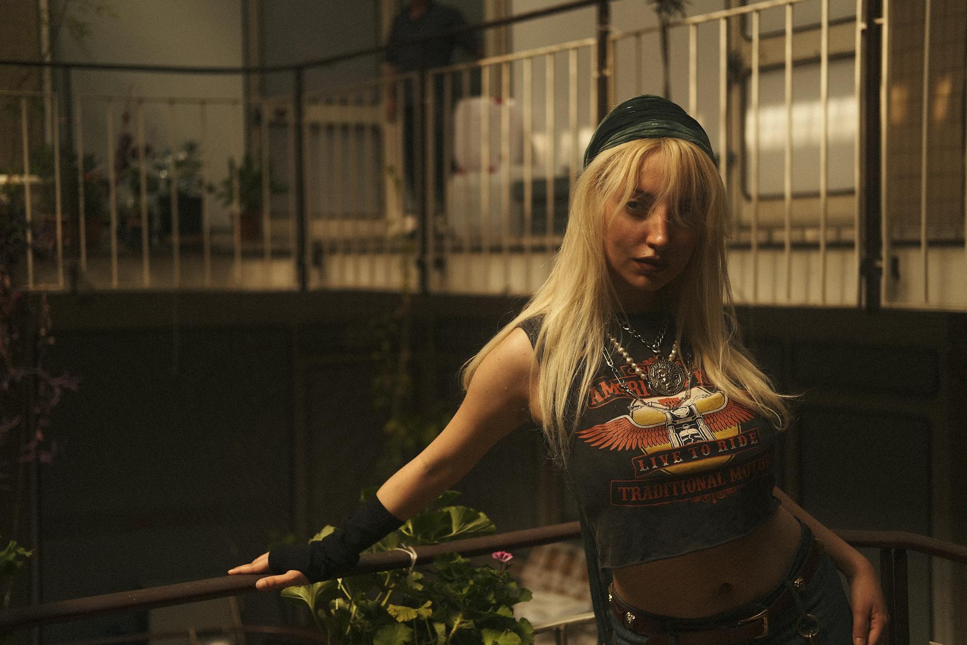 Pewna siebie blondynka oparta o barierkę w nowoczesnym wnętrzu