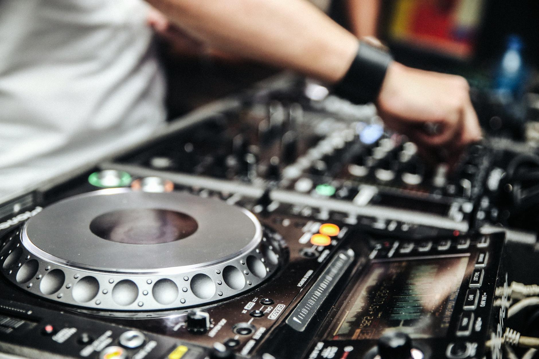 Dłonie DJ-a na mikserze podczas nocnej imprezy w jamajskim stylu