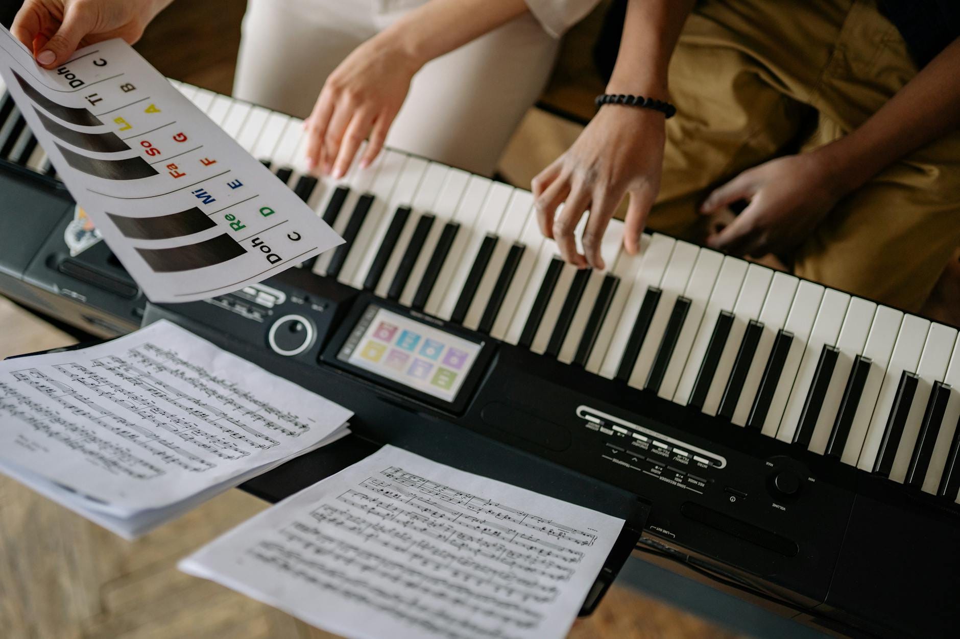 Dłonie grające na pianinie z nutami podczas lekcji muzyki