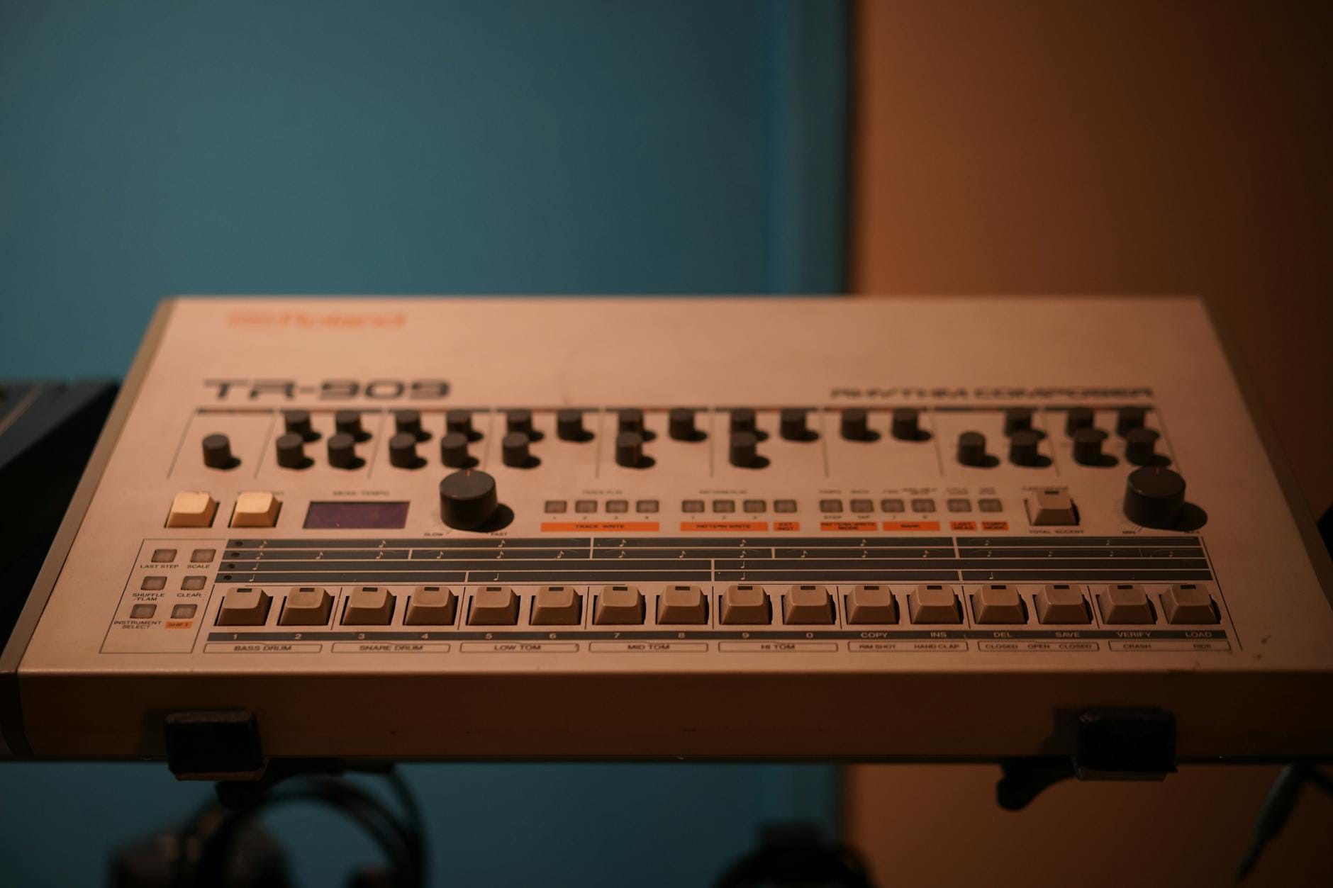 Zbliżenie na klasyczny automat perkusyjny Roland TR-909 w studiu