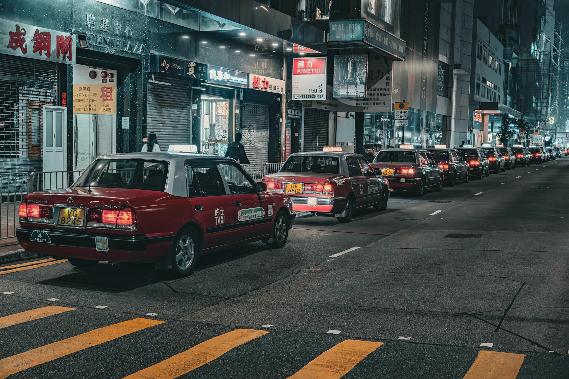 Nocna ulica pełna czerwonych taksówek w azjatyckim mieście